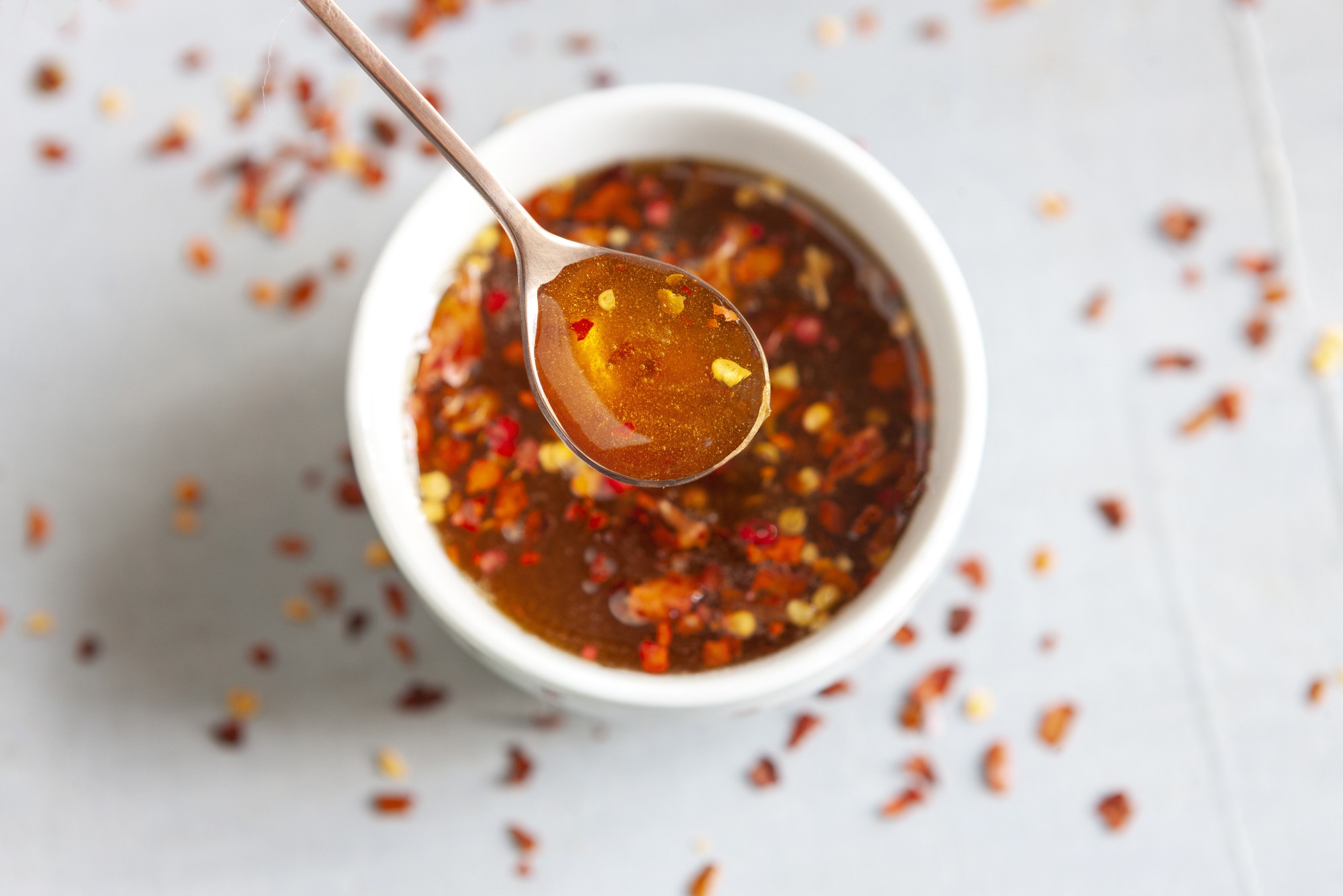 hot honey in the spoon and the bowl close up