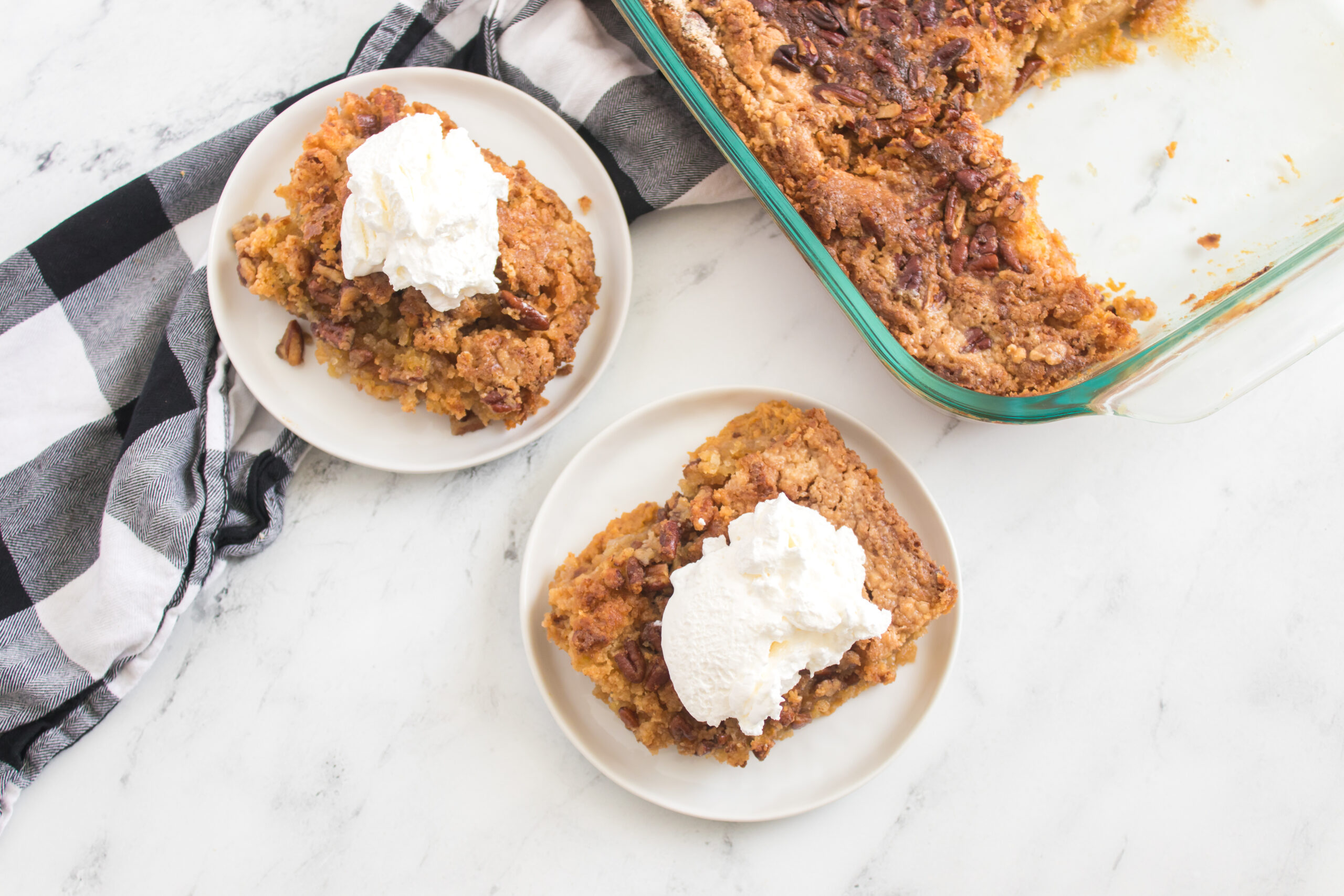 pumpkin spice crunch cake - two plates of crunch cake with a pan in the overhead shot