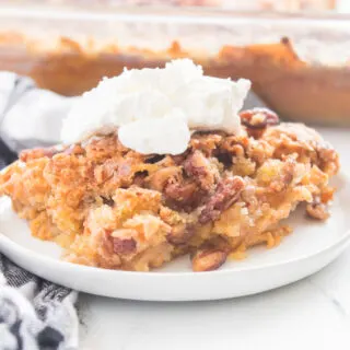 piece of pumpkin spice crunch cake on a plate with whipped cream